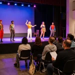 Engaged audience enjoying a live performance at ROKOK88 theatre, highlighting rokok88 login for community events.